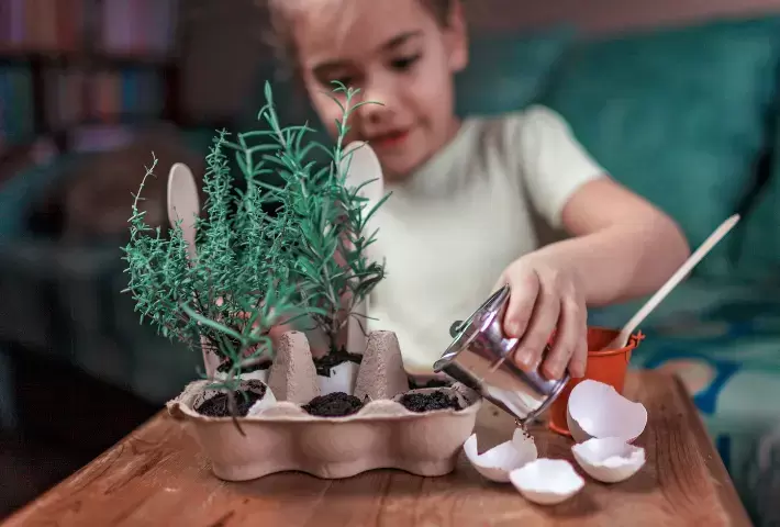 A girl is planting with ​upcycling materials